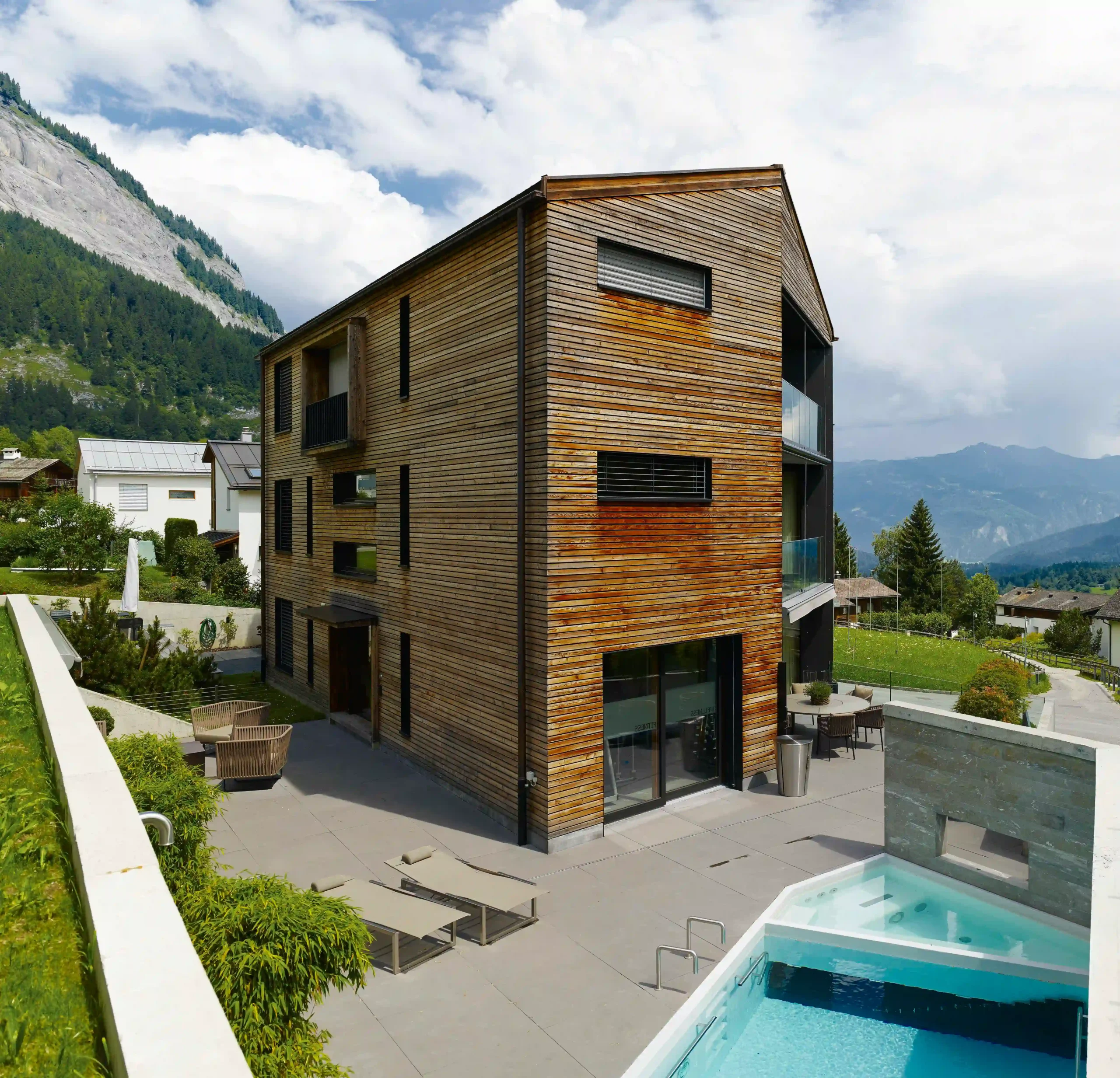 Doppelwohnhaus Luchsinger Pedersen Flims Dorf Gesamtaufnahme Haus und Garten mit Pool
