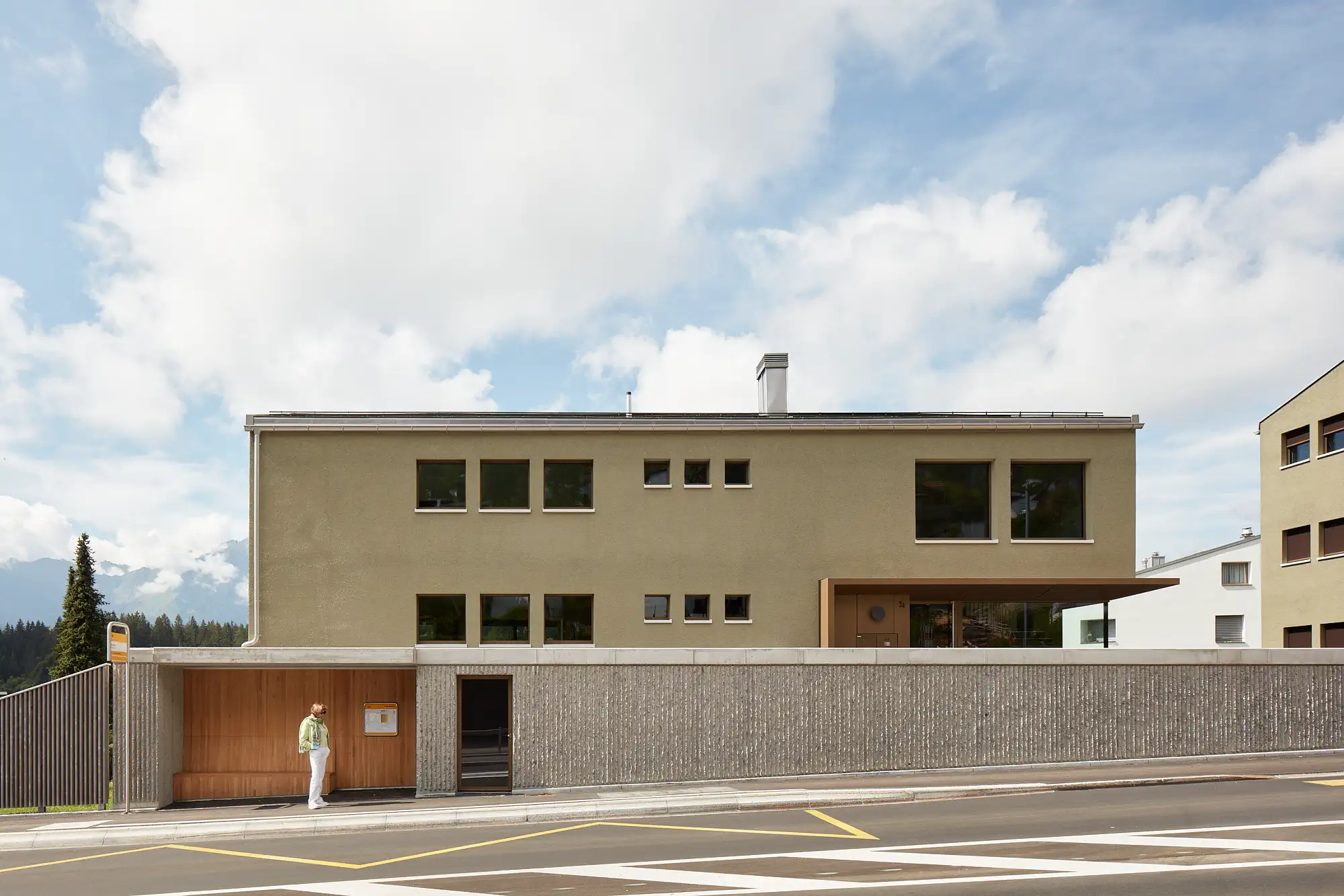 Haus Willi Flims Busshaltestelle mit den zwei Neubauten im Hintergrund
