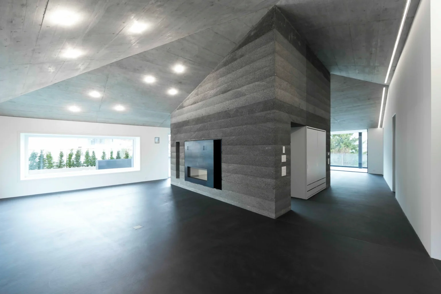 MFH Gassmann Flims Waldhaus Wohnzimmer mit Verputz und Sichtbeton