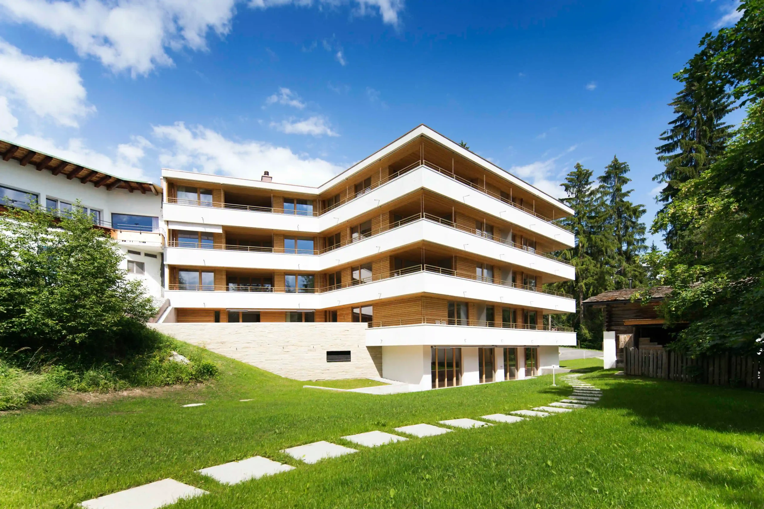 MFH Haus am Waldrand Flims Waldhaus Fassade Süd und Garten